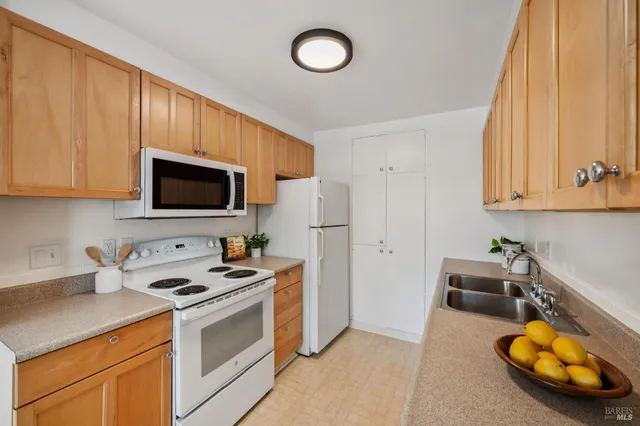 a kitchen with stainless steel appliances a stove a microwave and white cabinets