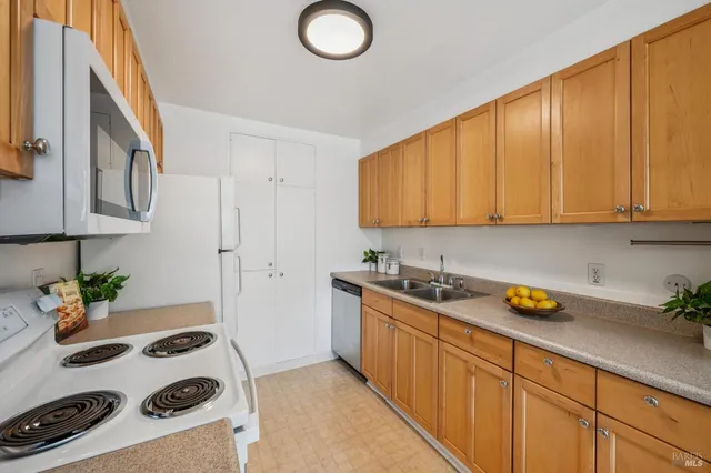 a kitchen with a sink a stove and cabinets