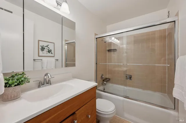 a bathroom with a sink a mirror a toilet and shower