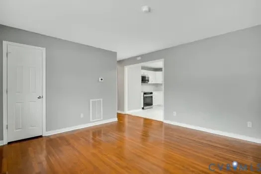 a view of empty room with wooden floor