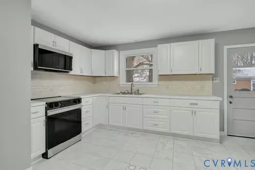 a kitchen with granite countertop white cabinets stainless steel appliances and sink