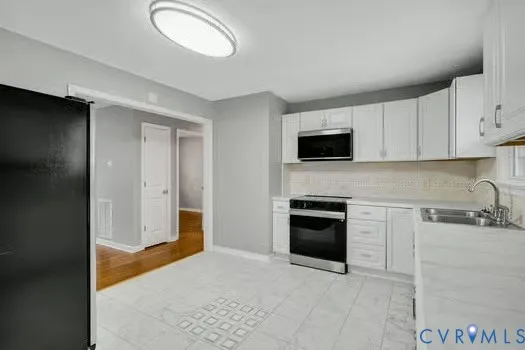 a kitchen with stainless steel appliances granite countertop a stove a sink and a refrigerator