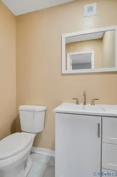 a bathroom with a toilet a sink and mirror