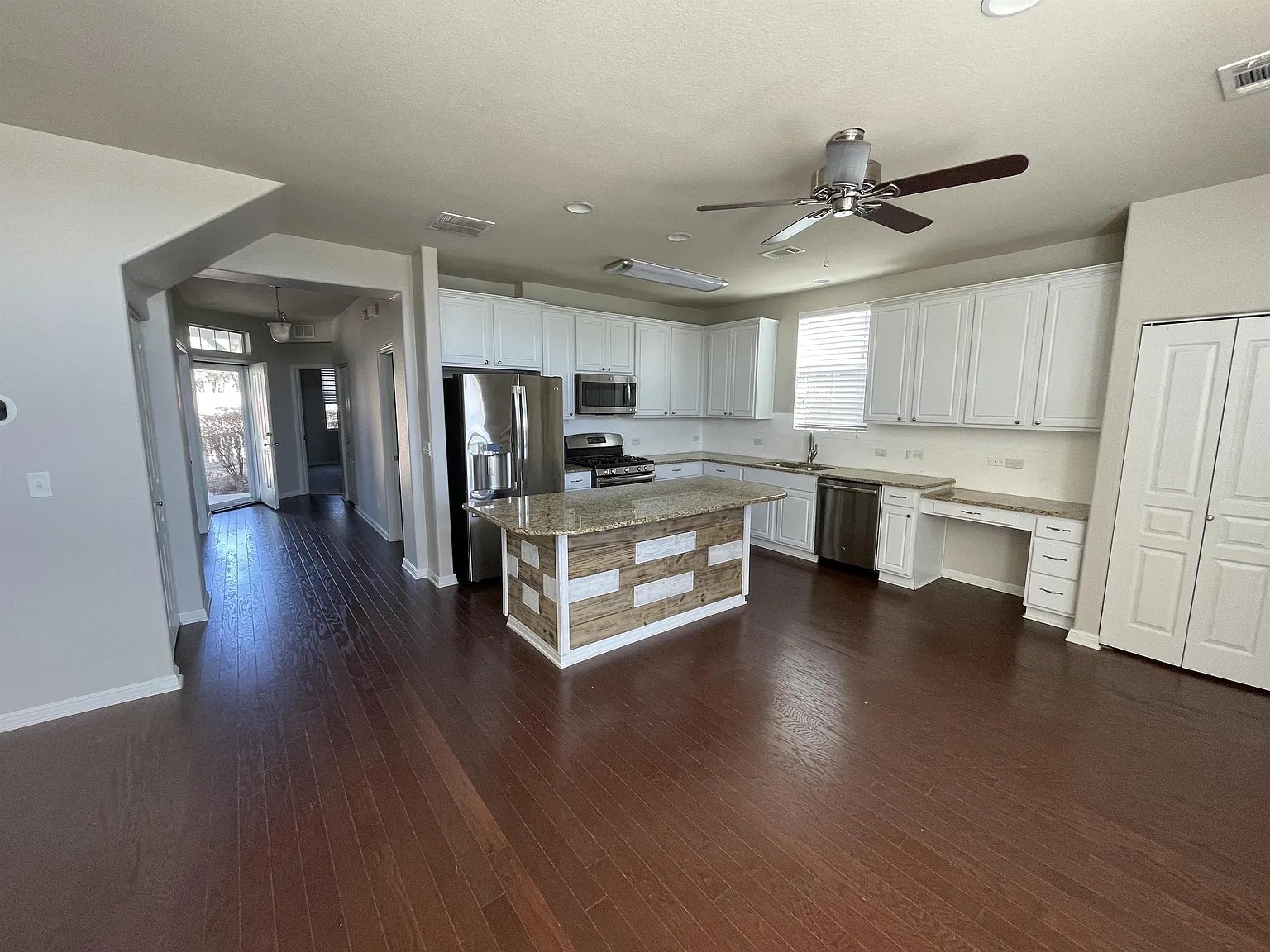 5136 Hellman Kyle, TX 78640 - Photo 3 of 17 Kitchen with white cabinetry, appliances with stainless steel finishes, a kitchen island, and dark wood finished floors