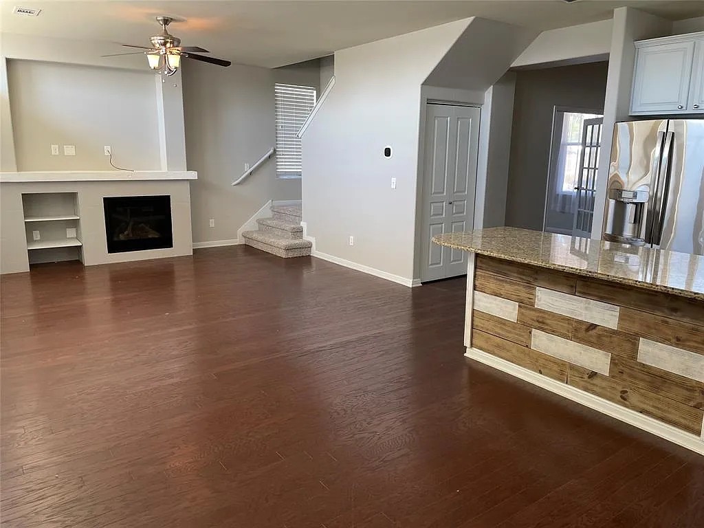 5136 Hellman Kyle, TX 78640 - Photo 4 of 17 Unfurnished living room with stairway, dark wood-type flooring, ceiling fan, and a fireplace