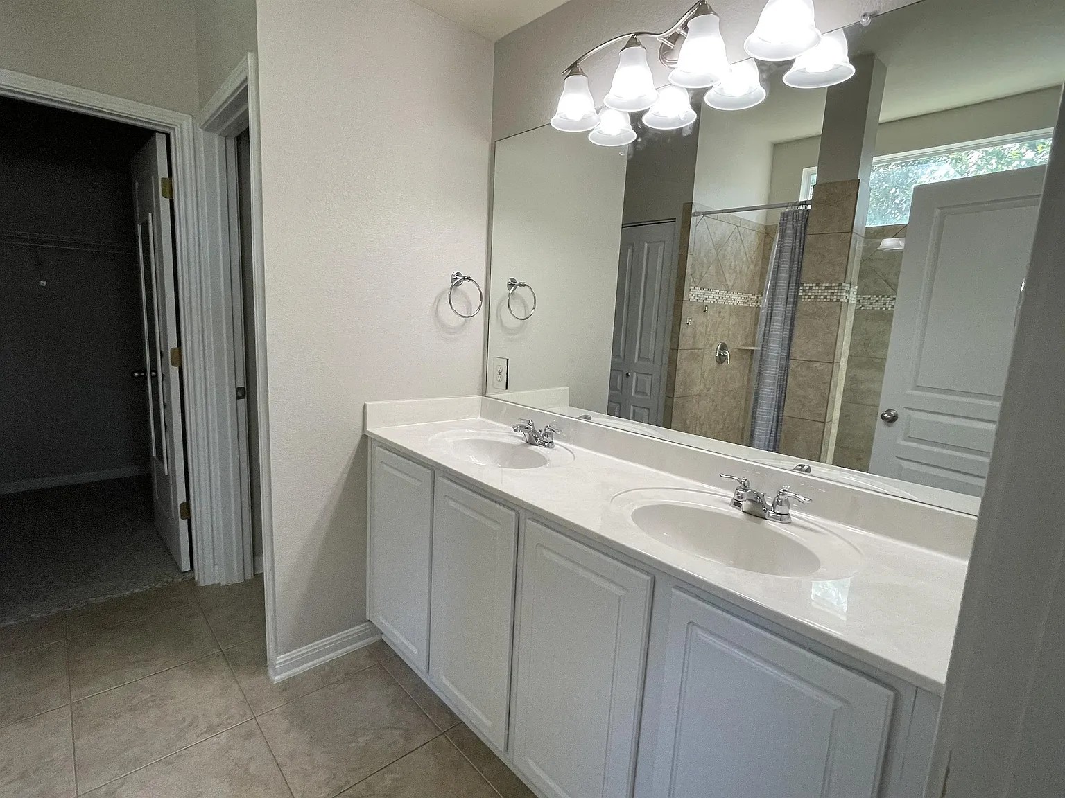5136 Hellman Kyle, TX 78640 - Photo 10 of 17 Full bathroom featuring a shower stall, double vanity, a walk in closet, and light tile patterned flooring