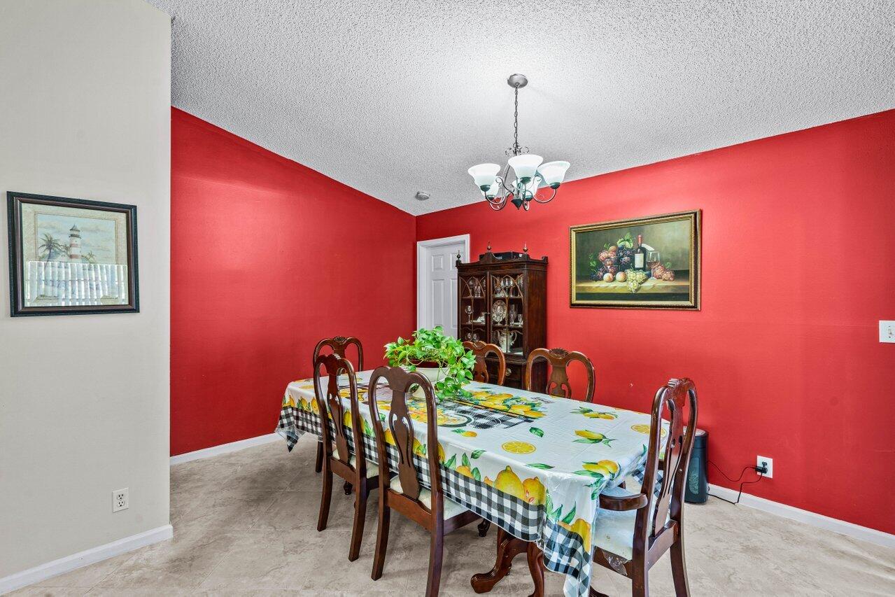 2195 Northwest 14th Street Delray Beach, FL 33445 - Photo 13 of 44 a view of a dining room with furniture and a chandelier