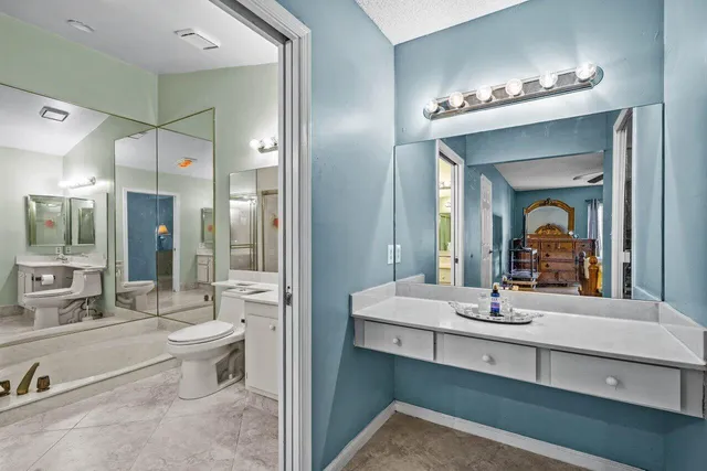 a bathroom with a double vanity sink mirror and bathtub