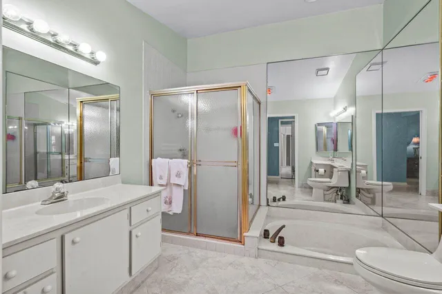 a bathroom with a double vanity sink toilet mirror and bathtub