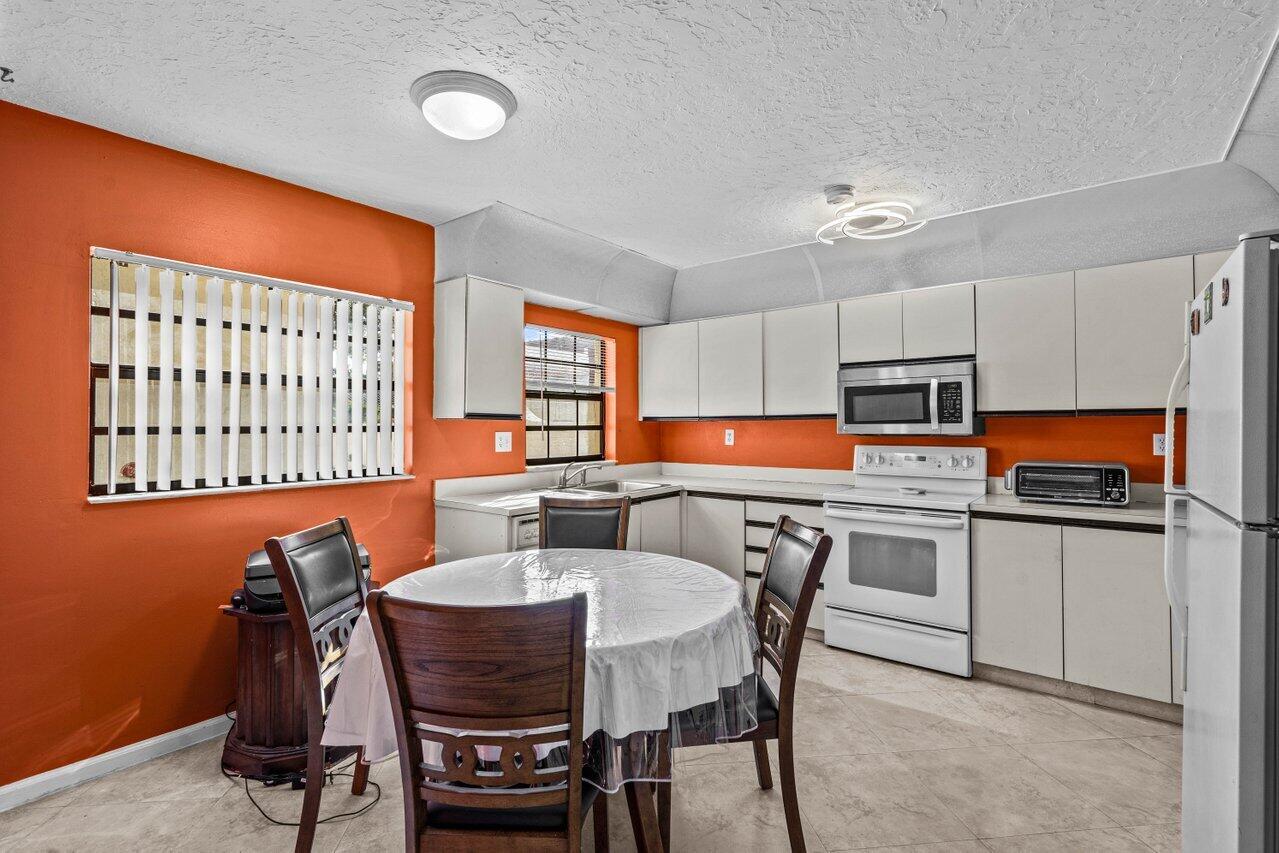 2195 Northwest 14th Street Delray Beach, FL 33445 - Photo 20 of 44 a view of a dining room with furniture and a chandelier