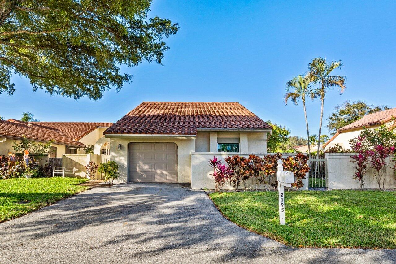 2195 Northwest 14th Street Delray Beach, FL 33445 - Photo 2 of 44 a front view of a house with garden