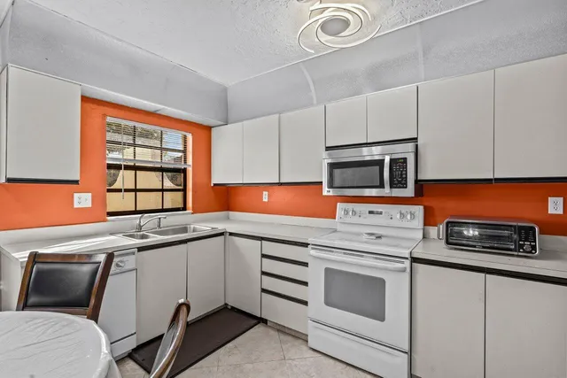 a kitchen with stainless steel appliances a stove a sink and a microwave