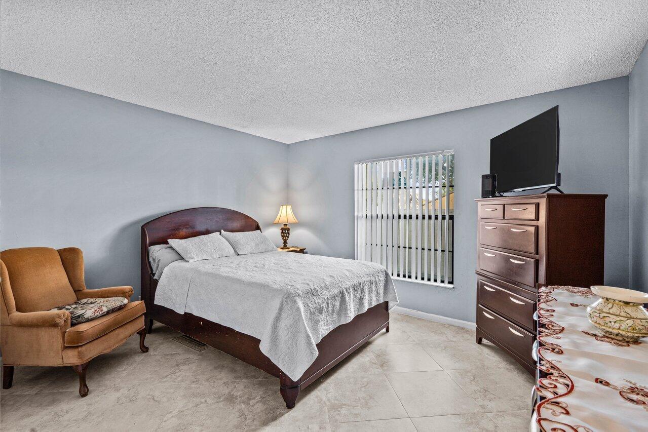 2195 Northwest 14th Street Delray Beach, FL 33445 - Photo 24 of 44 a bedroom with a bed and a television