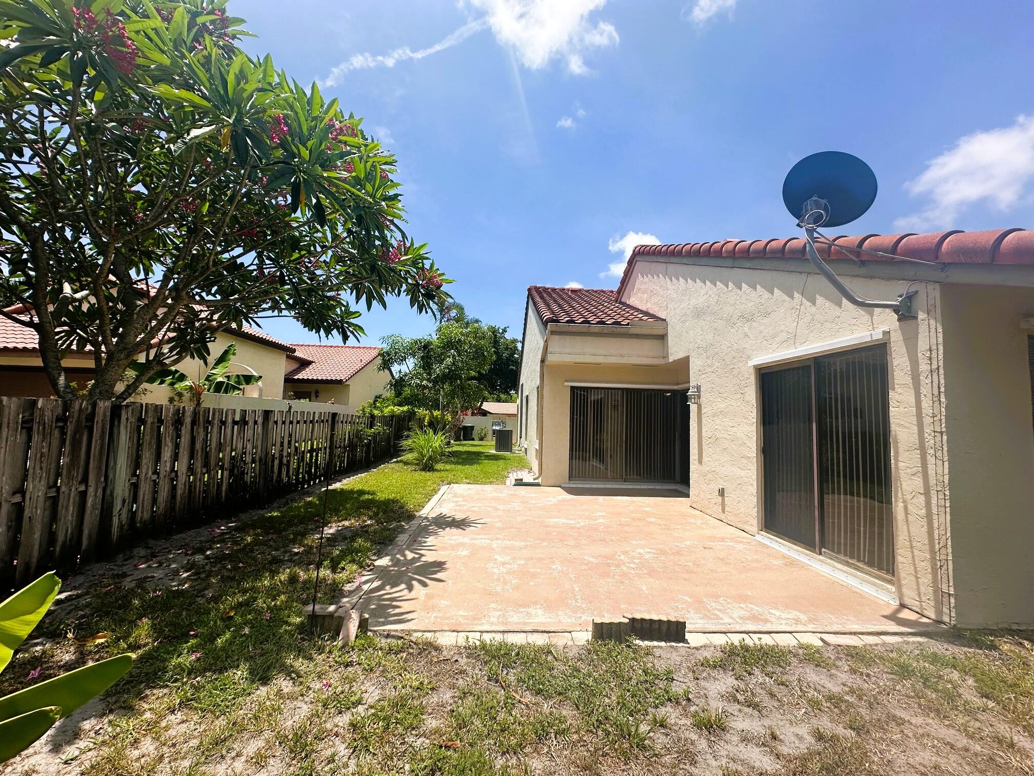 2195 Northwest 14th Street Delray Beach, FL 33445 - Photo 29 of 44 a very nice looking house with a large tree in front of it