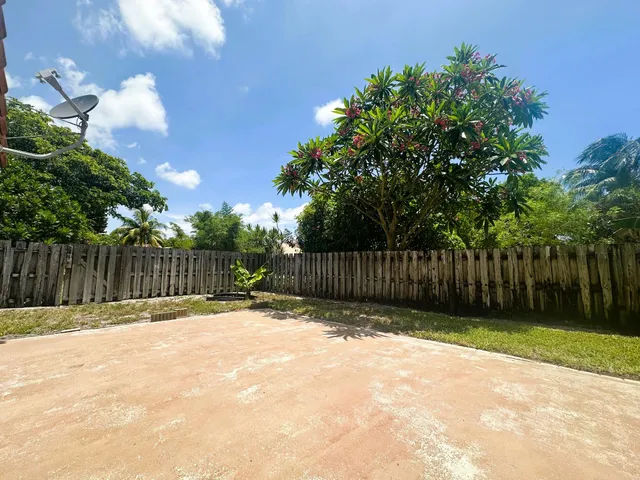 a view of backyard with wooden fence