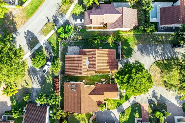 an aerial view of residential houses with outdoor space and trees