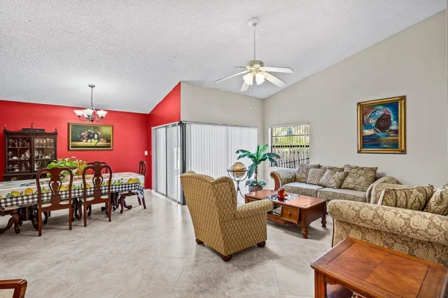 a living room with furniture a chandelier and a window