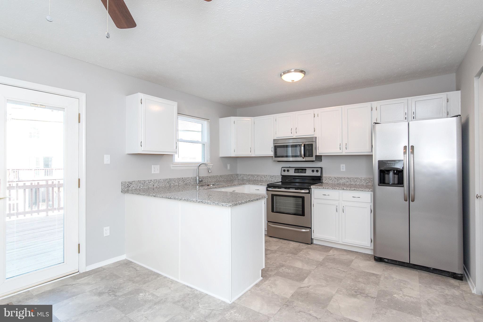 426 Kosoak Road Baltimore, MD 21220 - Photo 7 of 30 a kitchen with stainless steel appliances granite countertop a stove a sink and a refrigerator