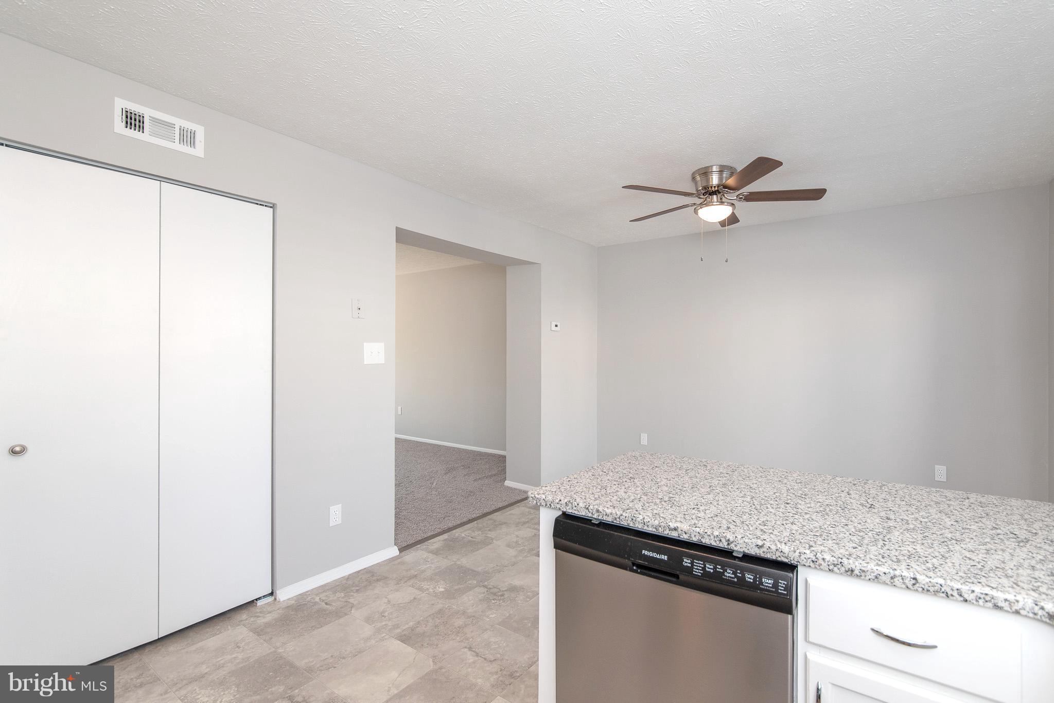 426 Kosoak Road Baltimore, MD 21220 - Photo 8 of 30 an empty room with a granite counter top and a ceiling fan