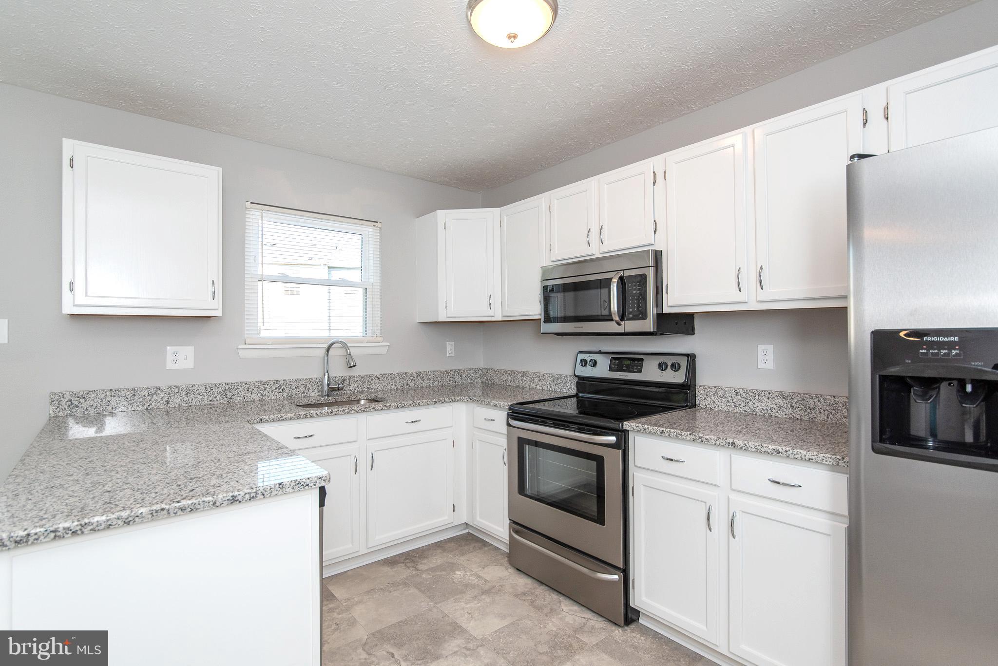 426 Kosoak Road Baltimore, MD 21220 - Photo 10 of 30 a kitchen with granite countertop white cabinets sink and stainless steel appliances