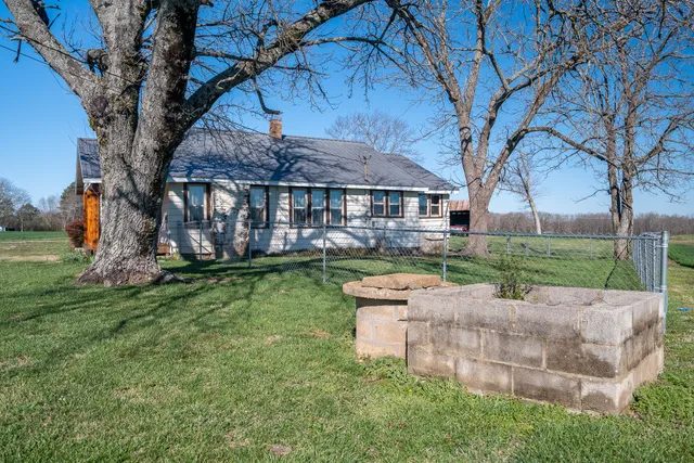 front view of a house with a big yard and large tree