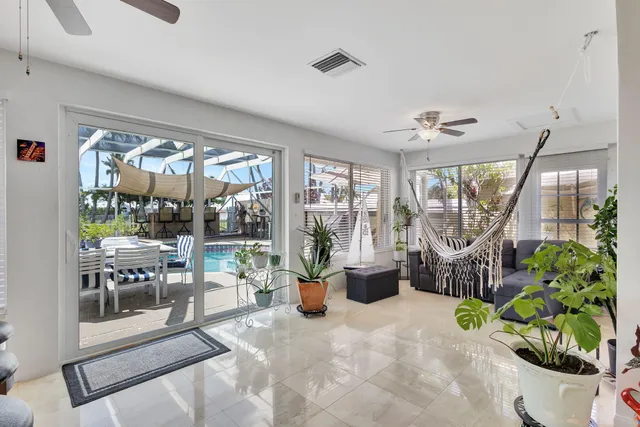 a living room with furniture a dining table and a potted plant