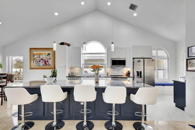 a kitchen with stainless steel appliances kitchen island granite countertop a table and chairs
