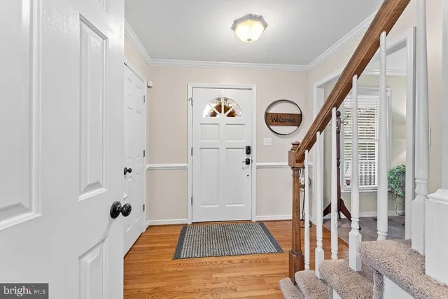 a view of a hallway with wooden floor and staircase