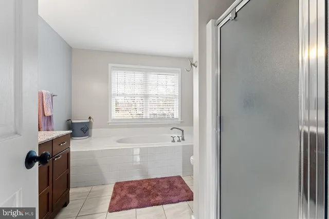 a bathroom with a granite countertop sink a toilet and a shower curtain