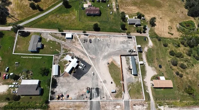 an aerial view of a house with a yard and large trees