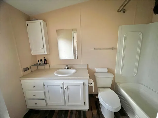 a bathroom with a granite countertop toilet a sink and a mirror