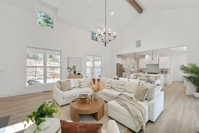 a living room with furniture chandelier and a window
