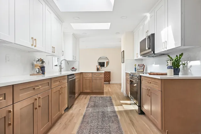 a kitchen with cabinets stainless steel appliances and a sink