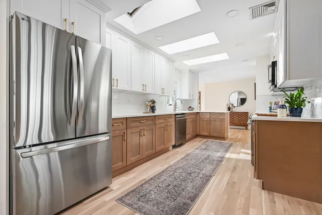 a dining room with wooden floor a glass table and chairs
