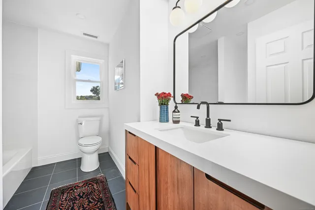 a front view of a house with a yard and green space