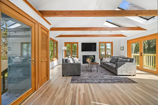 a living room with furniture a large window and a flat screen tv