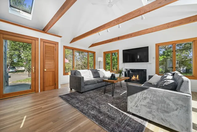 a living room with fireplace furniture and a large window