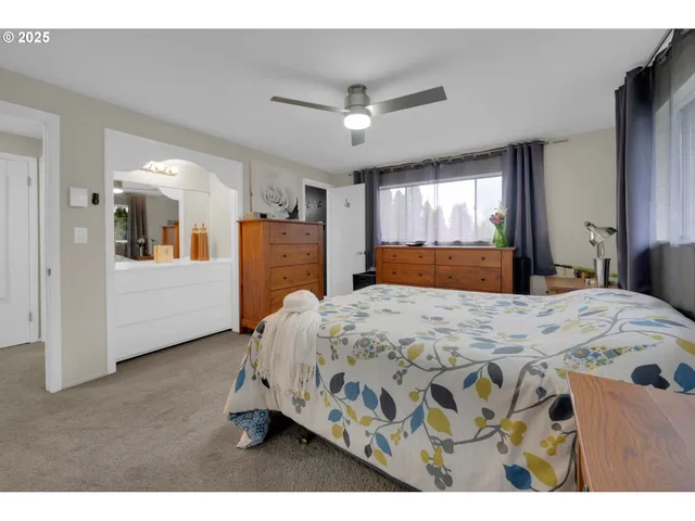 a bedroom with a bed a window and dresser