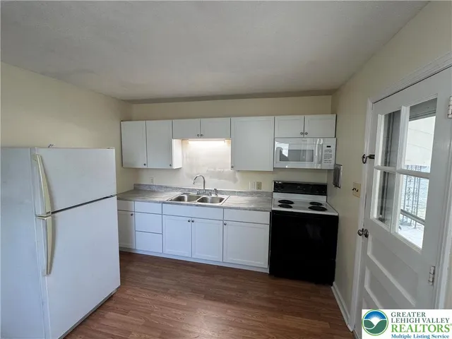 a kitchen with stainless steel appliances a refrigerator sink and cabinets