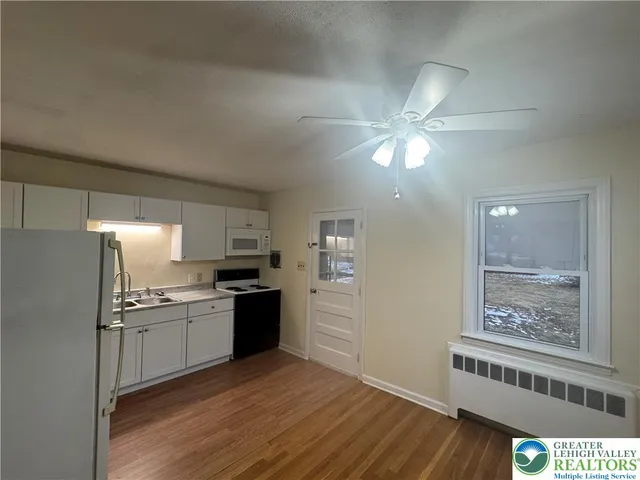 a kitchen with granite countertop a refrigerator and a stove top oven