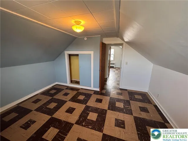 a bedroom with a bed and a lamp on the dresser