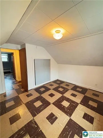 a bedroom with a bed and a black white checkered floor