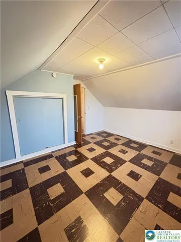 a bedroom with a bed and a black white checkered floor