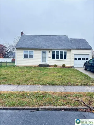 a view of a house with backyard and a tree