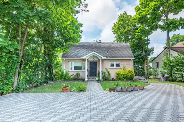 a view of a house with a yard and large tree and plants