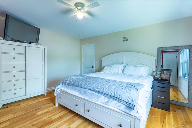 a bedroom with a bed and a flat tv screen on dresser
