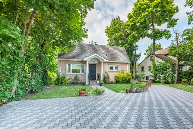 a front view of a house with a yard and potted plants