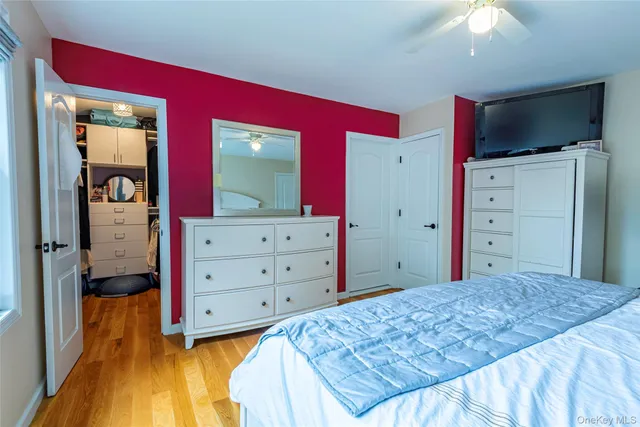 a bedroom with a bed and a flat tv screen on dresser