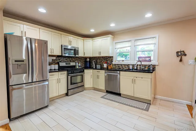 a kitchen with stainless steel appliances granite countertop a refrigerator sink and cabinets
