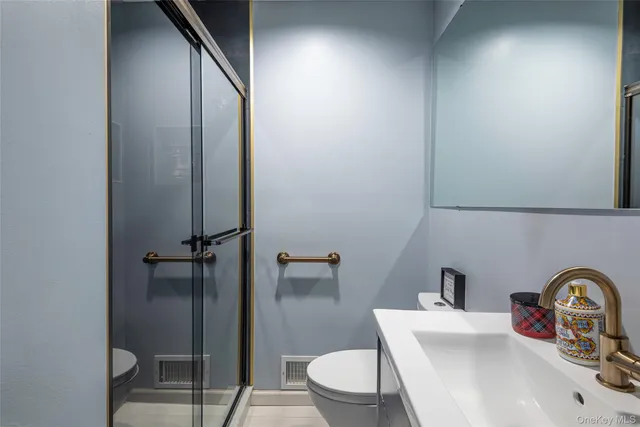 a bathroom with a toilet sink vanity and mirror